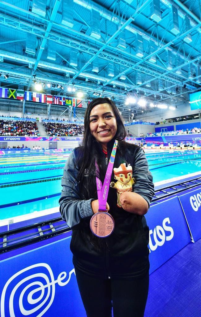 Para nadadora peruana muestra su medalla junto a la piscina