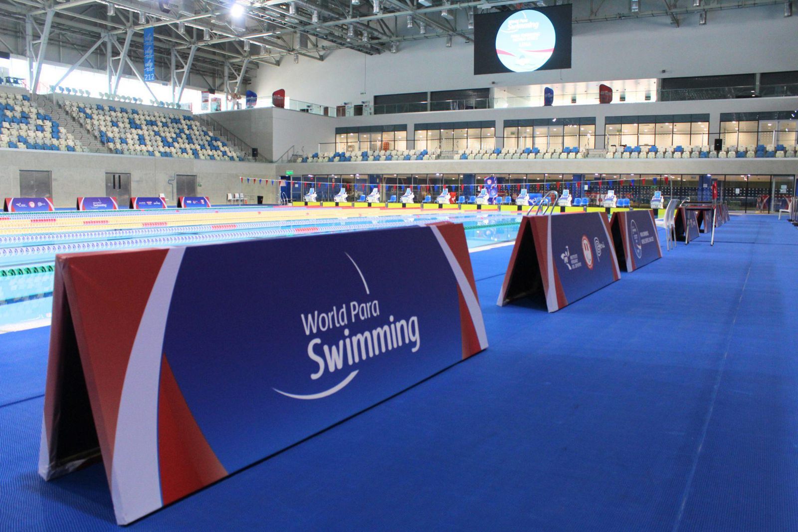 Paneles del circuito mundial de para natación al borde de la piscina